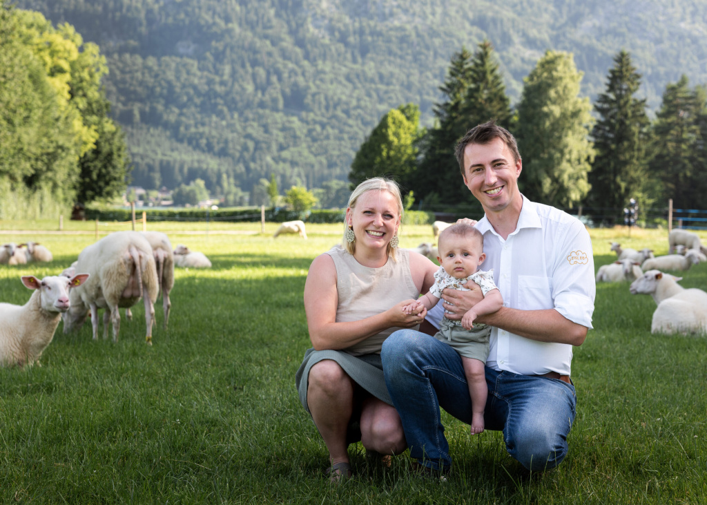 Familie mit Baby auf einer Schafweide